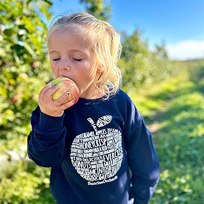 Little girl eating an apple at Sunrise Orchards